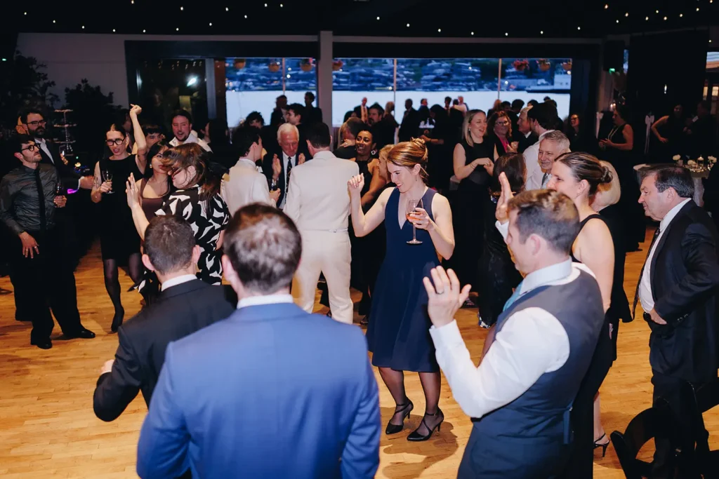 Guests dancing on the main room's wood floor under string lights and a starlit ceiling treatment.