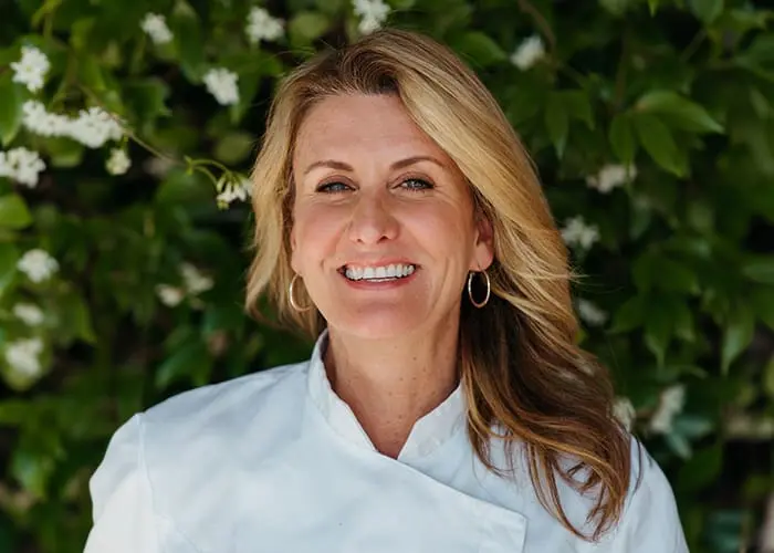 Headshot of Elizabeth Betancourt, Food and Beverage Officer at The Extra Ingredient, wearing a chef's coat.